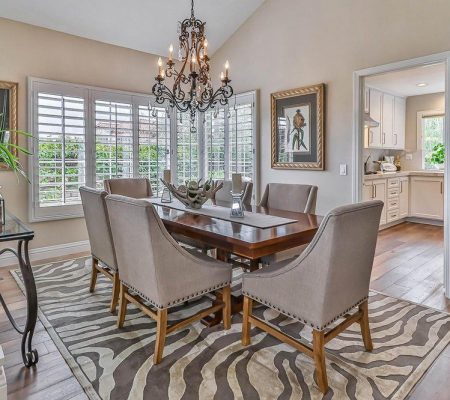A stylish dining room featuring a zebra rug and an elegant chandelier hanging from the ceiling.