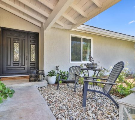 A cozy home featuring a front porch with two inviting chairs.