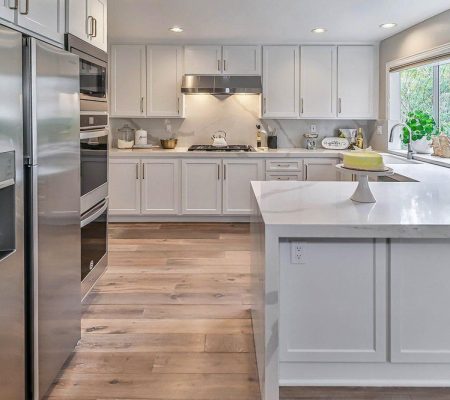 A clean kitchen featuring white cabinets and stainless steel appliances, showcasing a modern and organized space.
