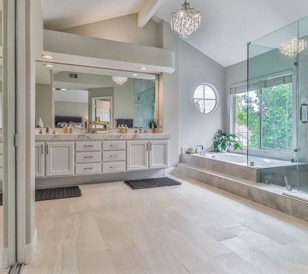 A spacious bathroom featuring a large tub and a separate shower area.