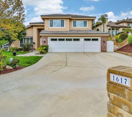 A house featuring a driveway leading to an attached garage.