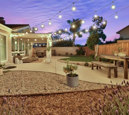A cozy backyard featuring a patio adorned with string lights, creating a warm and inviting atmosphere.