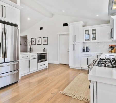 A modern kitchen featuring stainless steel appliances and warm wood floors, creating a stylish and inviting atmosphere.