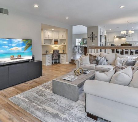 A spacious living room featuring a large flat screen TV mounted on the wall.
